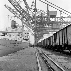 854154 Gezicht op een kade in de haven van Rotterdam, met rechts een rij goederenwagens en links het schip Johann ...